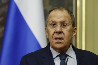 Сергій Лавров на пресконференції на тлі прапора Росії