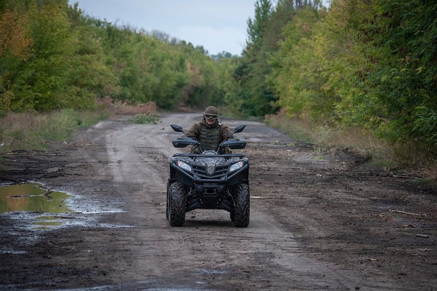 Військовий ЗСУ їде ґрунтовою дорогою на квадроциклі